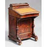 A Victorian burr walnut Davenport, the hinged writing surface above a cupboard and turned