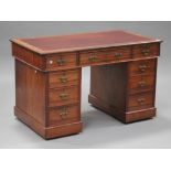 An Edwardian walnut twin pedestal desk, fitted with an arrangement of nine drawers, on plinth bases,
