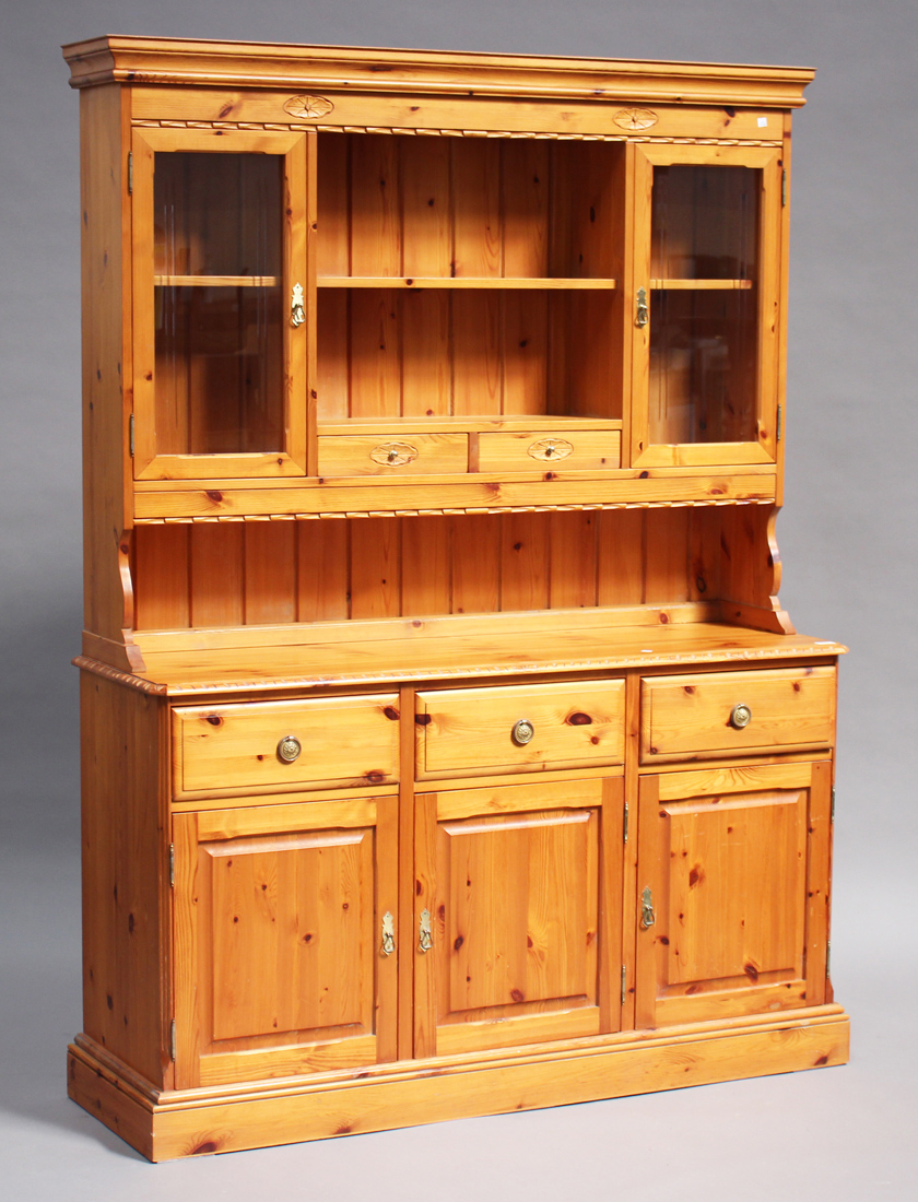 A late 20th century pine kitchen dresser, the shelf back above drawers and cupboards, on a plinth