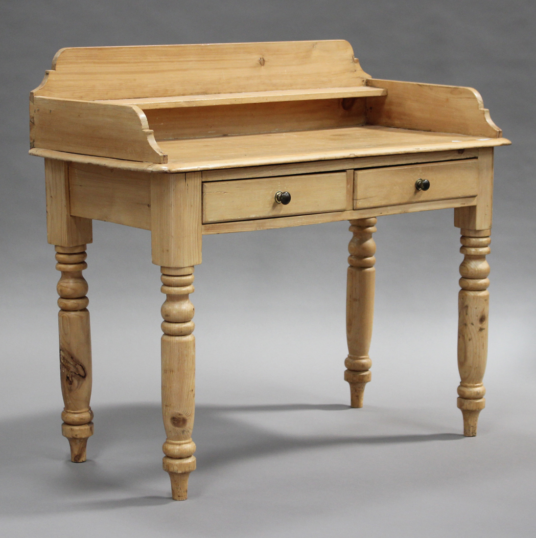 A Victorian stripped pine washstand, the three-quarter gallery back above two frieze drawers, raised