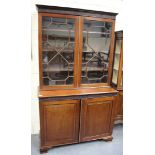 A 19th century mahogany bookcase cabinet with blind fretwork decoration, the moulded pediment