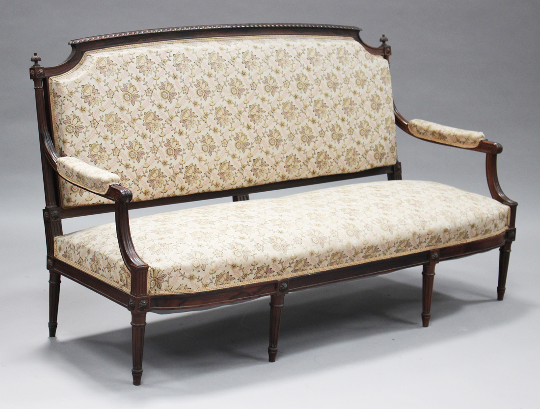 A late 19th/early 20th century French Louis XVI style rosewood framed salon settee with carved