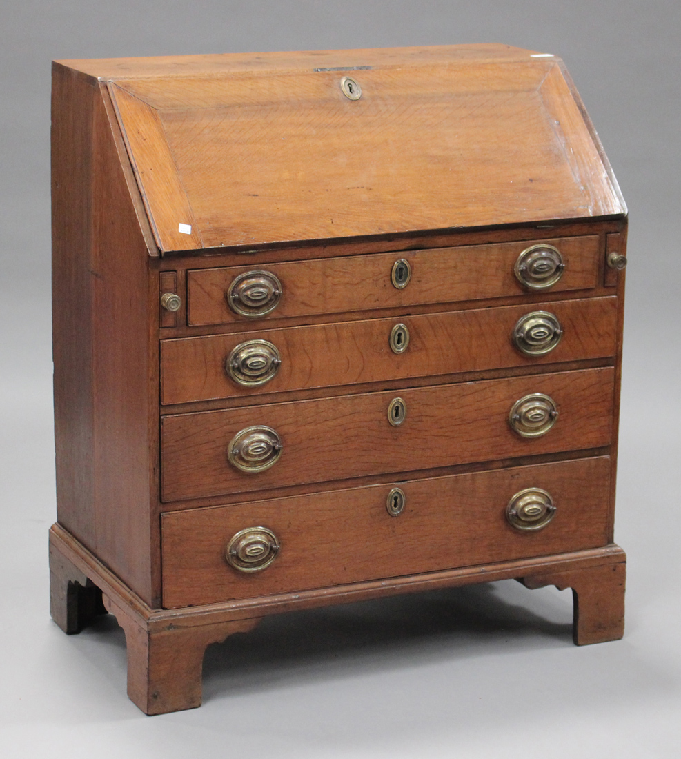 An 18th century oak bureau, the fall front revealing a fitted interior above four long drawers, on