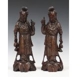 A pair of Chinese carved hardwood figures of maidens, early 20th century, each modelled standing