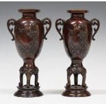 A pair of Japanese brown patinated bronze two-handled vases, Meiji period, each ovoid body cast in