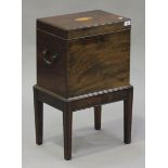 A George III mahogany rectangular cellaret and stand, the hinged lid inlaid with and oval shell