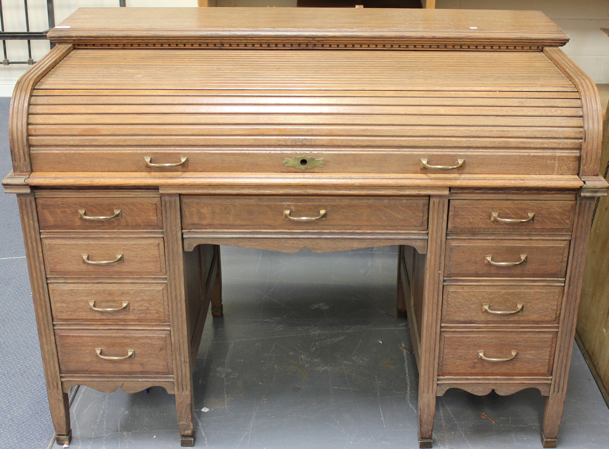 A 20th century oak roll-top desk, the tambour front revealing a fitted interior above an arrangement