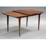 A mid-20th century teak extending dining table, after a design by Gordon Russell, raised on tapering