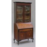 An Edwardian mahogany and inlaid bureau bookcase, the fall front above a drawer and cupboard, on