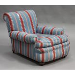 An early 20th century Howard & Sons style scroll armchair, upholstered in blue striped fabric, on