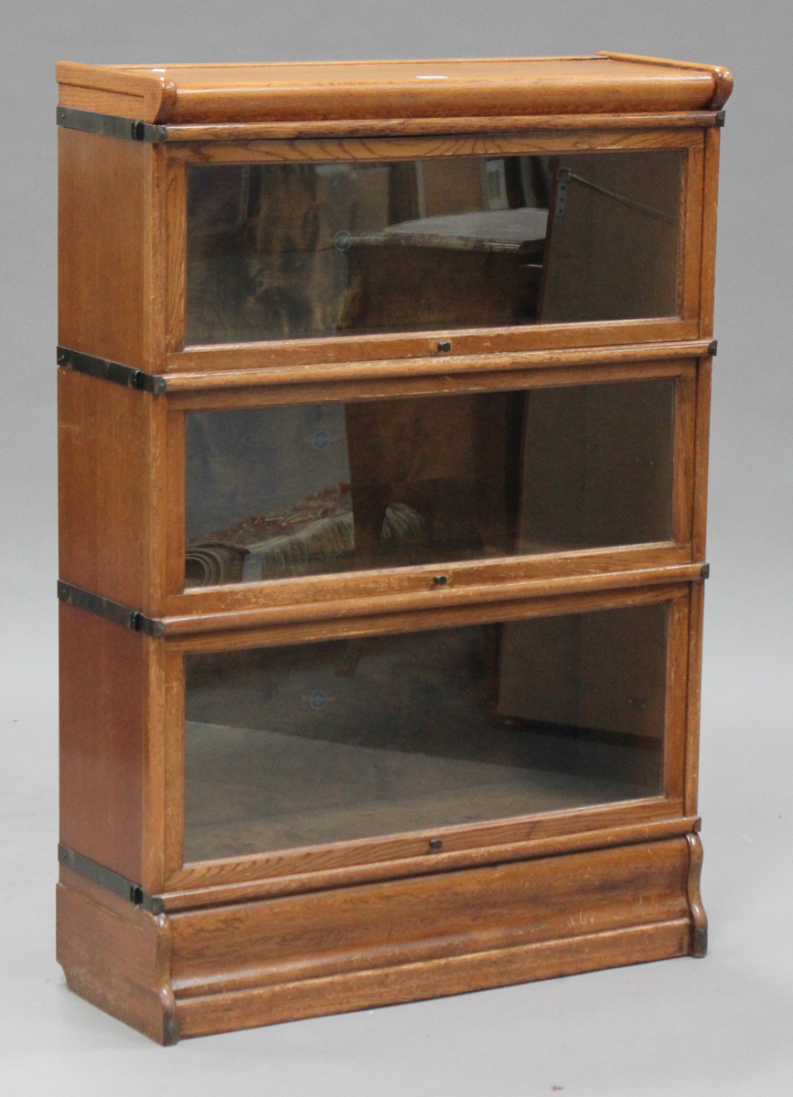 An early 20th century oak Globe Wernicke three-section glazed bookcase, with transferred maker's