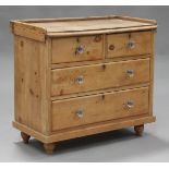 A Victorian pine chest of two short and two long drawers with moulded glass handles, on turned feet,
