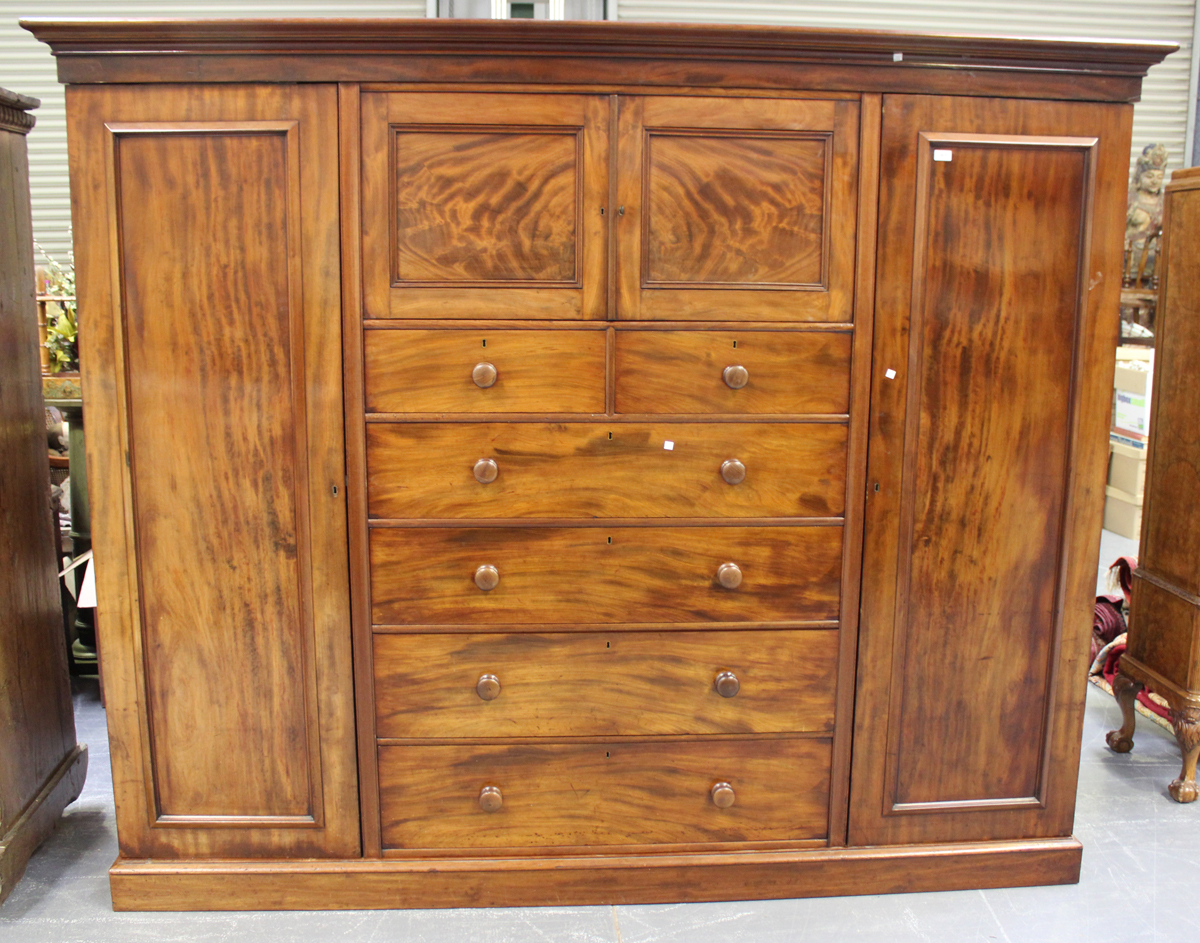 An early Victorian mahogany wardrobe, the moulded pediment above a cupboard and drawers, flanked