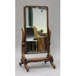 A mid-Victorian mahogany cheval mirror, the rectangular frame raised on scroll supports and a