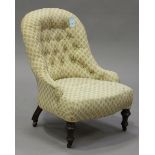 A late Victorian salon chair, upholstered in a foliate patterned damask, raised on turned walnut