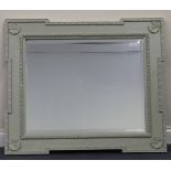A modern carved rectangular wall mirror, painted Farrow & Ball Estate Grey and decorated with