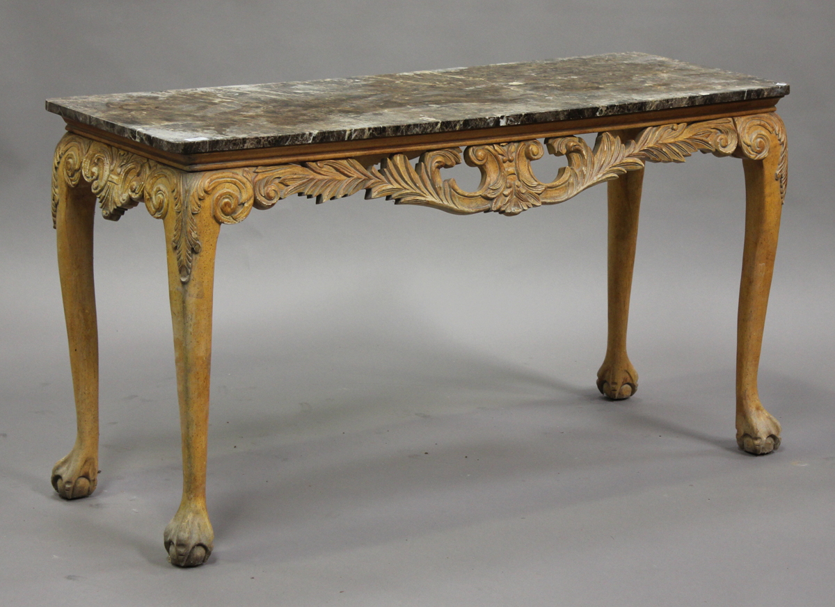 A 20th century Continental marble-topped centre table with carved and pierced scroll apron, on