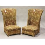 A pair of Art Deco wing back chairs, upholstered in pink floral fabric, on shaped block legs, height