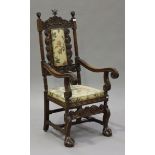 A late 19th century walnut armchair, the frieze carved with a coat of arms and leaf swags flanked by