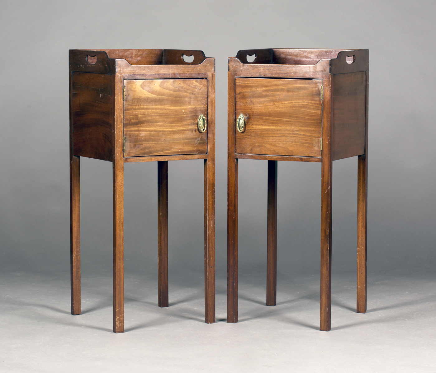 A pair of 19th century mahogany bedside cabinets, each galleried top with pierced handles above a