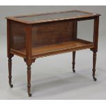 A late Victorian mahogany and glazed display case, the hinged top above glazed sides, raised on