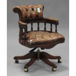 A 20th century reproduction mahogany revolving office chair, upholstered in buttoned brown