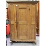 An 18th century Continental oak cupboard, the carved pediment above a single panelled door, on