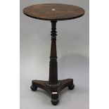 A William IV rosewood wine table, the circular top above a carved acanthus leaf stem and a triform