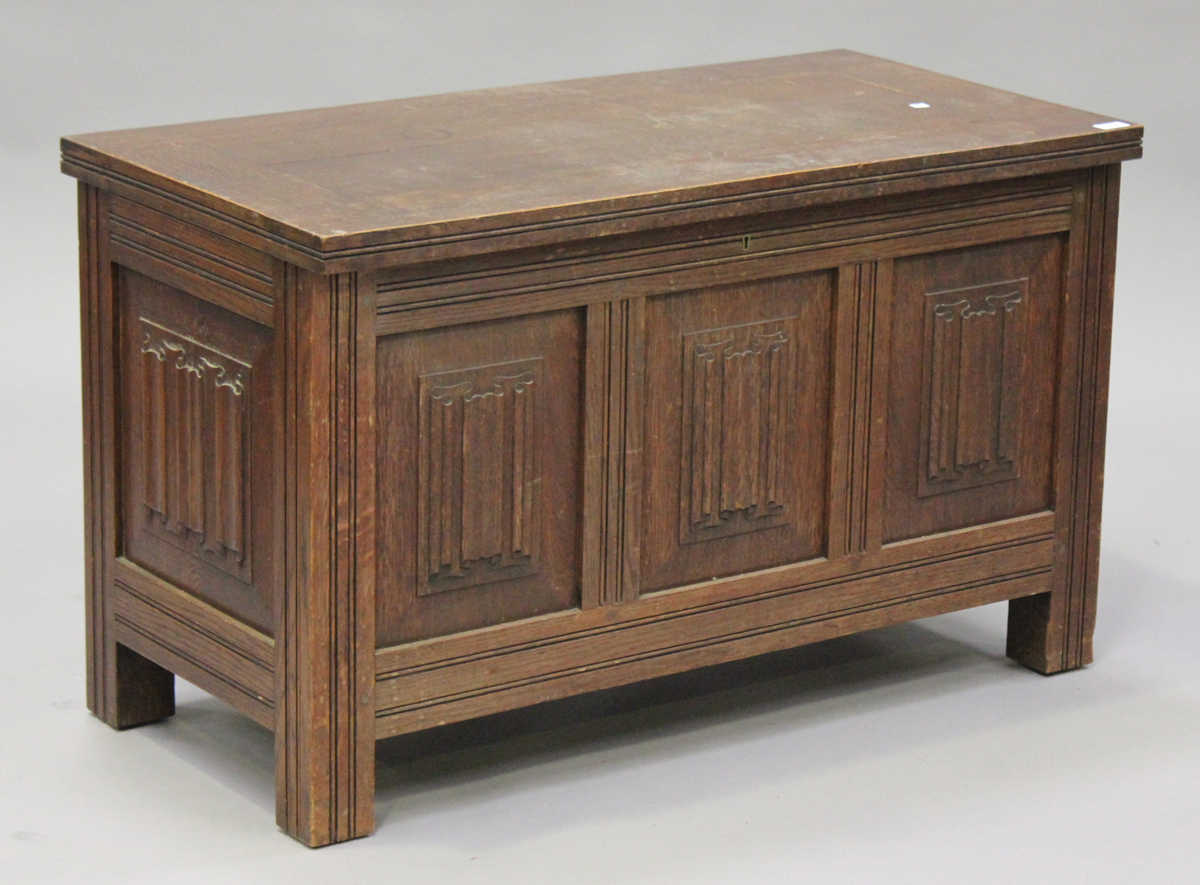 A 20th century oak coffer, the hinged lid above carved linenfold panel sides, on stiles supports,