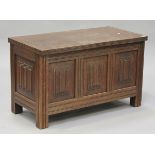 A 20th century oak coffer, the hinged lid above carved linenfold panel sides, on stiles supports,