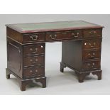 A late 20th century reproduction mahogany twin pedestal desk, fitted with a leather writing