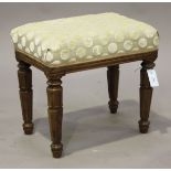 A William IV mahogany stool, the padded seat upholstered in spotted fabric, raised on carved tulip