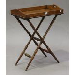 A Victorian oak diminutive butler's tray and folding stand, the raised gallery with pierced handles,