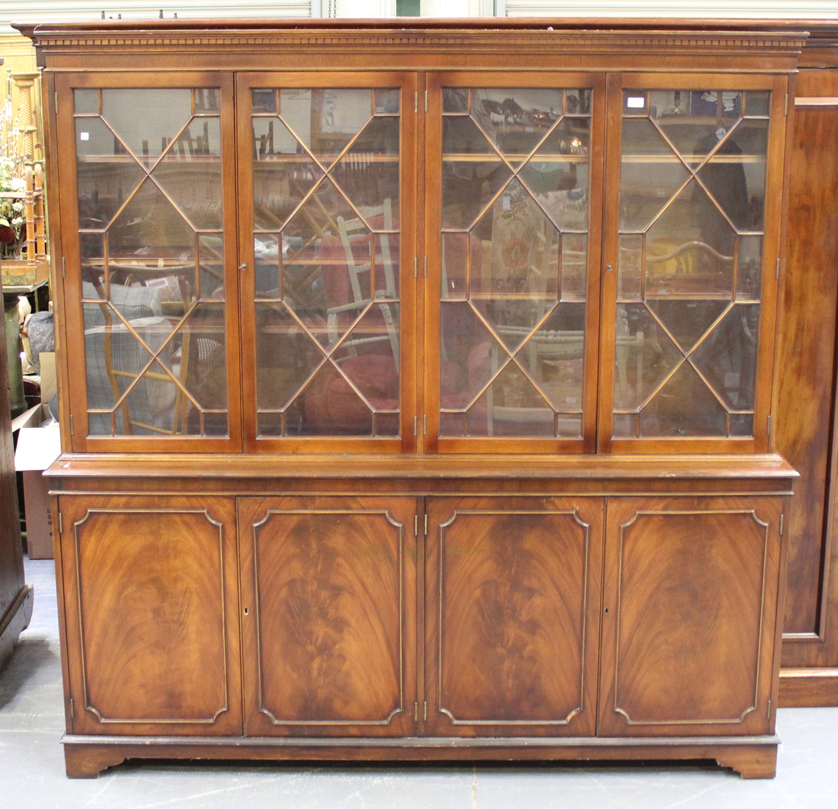 A late 20th century George III style mahogany four-section bookcase cabinet on bracket feet,