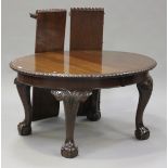 A George V mahogany 'D' end extending dining table with two extra leaves, raised on carved
