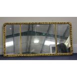 A late 19th century giltwood rectangular wall mirror, the three-section glass within a carved frame,