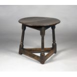 A late 17th century oak cricket table, the circular top raised on turned and block legs united by