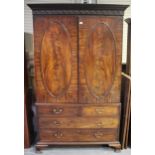 An early George III mahogany linen press, the dentil moulded pediment with a fluted and roundel