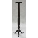 A 19th century mahogany bedpost torchère, the circular top raised on a reeded column and tripod