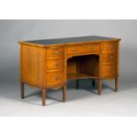 An Edwardian satinwood breakfront writing desk, the crossbanded top inset with a black leather