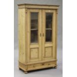 A late 20th century pine side cabinet, fitted with a pair of glazed panel doors and a drawer, on