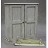 A 20th century painted pine side cabinet, fitted with a pair of panelled doors, on a plinth base,