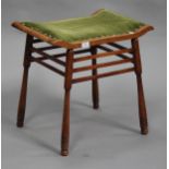 An early 20th century Arts and Crafts style stained beech stool, the upholstered seat raised on