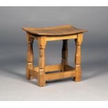 A Robert 'Mouseman' Thompson oak stool, the slightly dished seat raised on chamfered block and