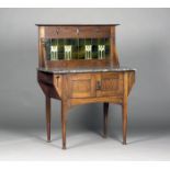 An Edwardian Arts and Crafts oak washstand, the pierced back inset with glazed tiles above a