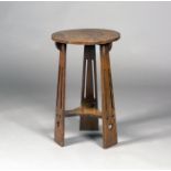 An Edwardian Arts and Crafts oak circular occasional table, possibly by Liberty & Co, the circular