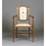 An Edwardian mahogany and inlaid elbow chair, probably made by J.S. Henry, the padded back panel and