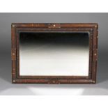 An early 20th century Arts and Crafts style oak framed wall mirror, the rectangular bevelled glass