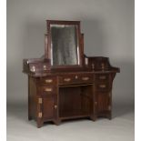 An Edwardian Arts and Crafts mahogany dressing chest with applied copper mounts, the swing mirror