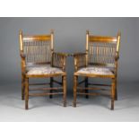 A pair of late Victorian Arts and Crafts style walnut armchairs, the turned spindle backs above